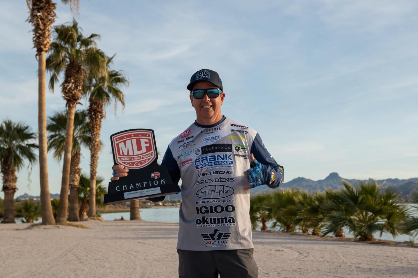 A person posing with a Major League Fishing trophy