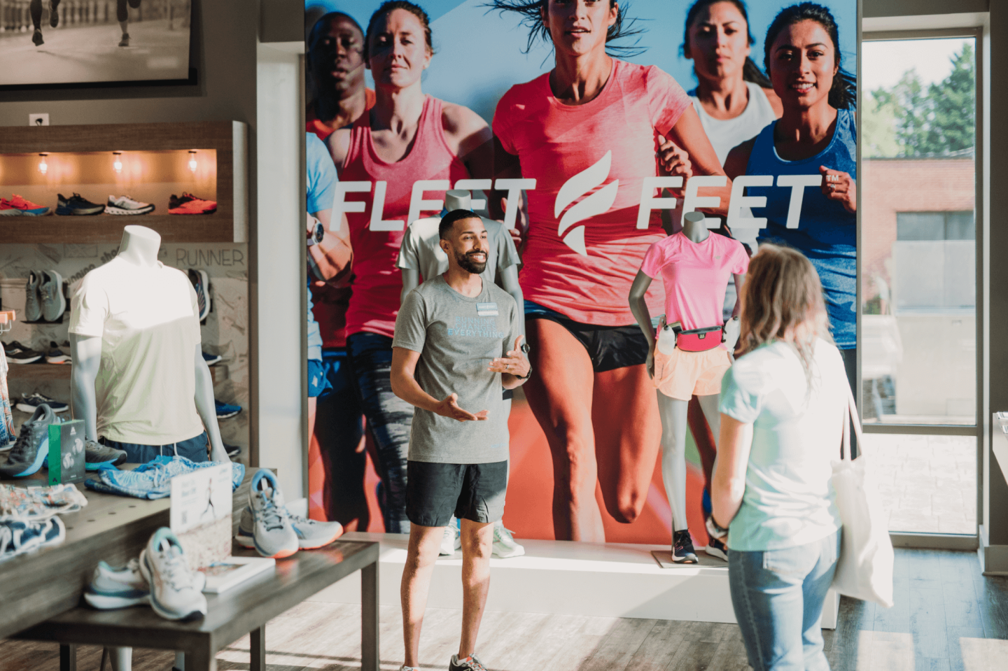 A customer speaking to a sales rep in a Fleet Feet store