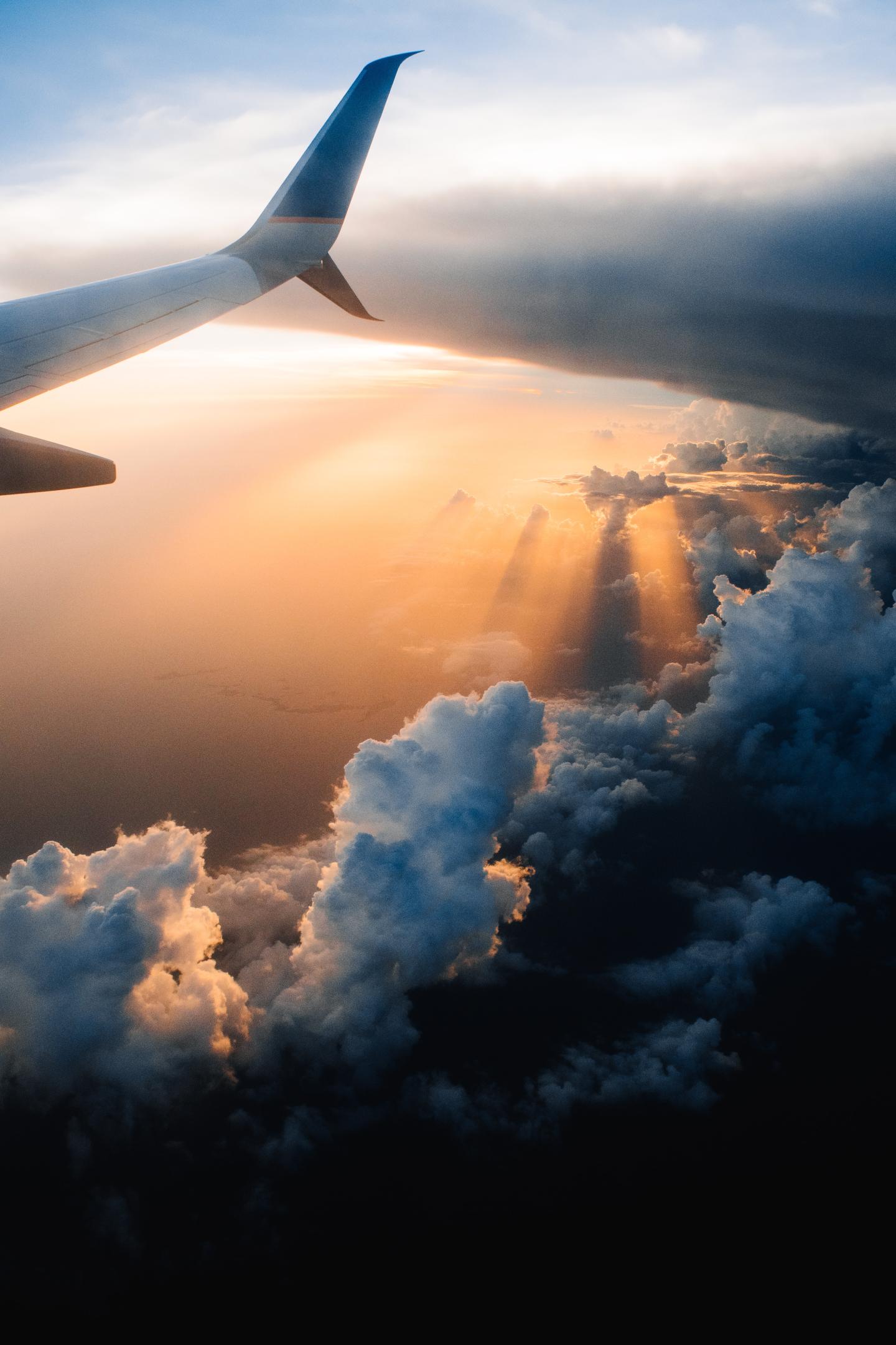 A view of an airplane wing above clouds