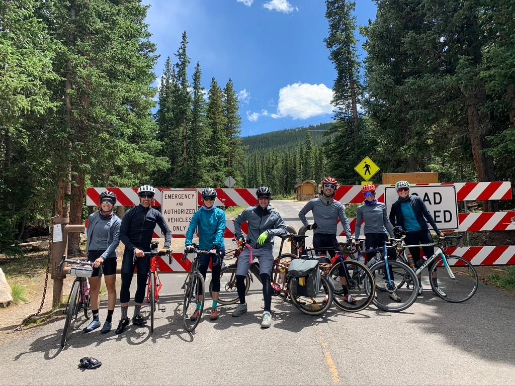 A group of bikers pose for a photo in front of a road closure