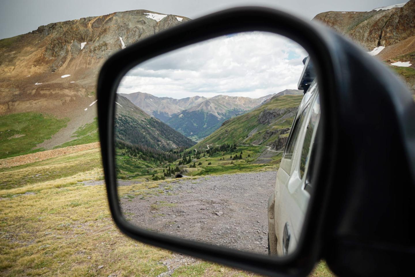 A car wing mirror showing a mountain range