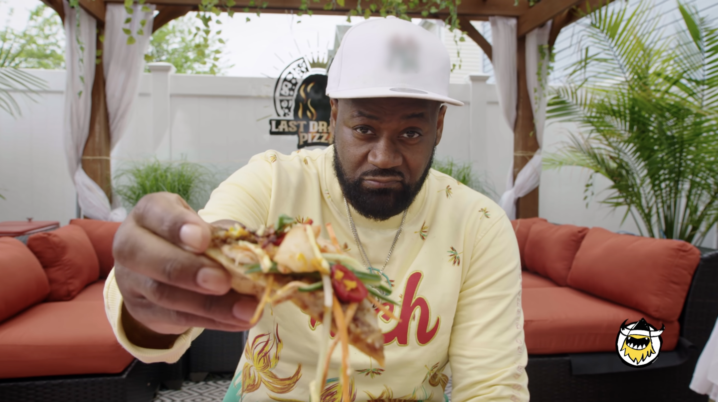 A person holding a slice of pizza up to the camera