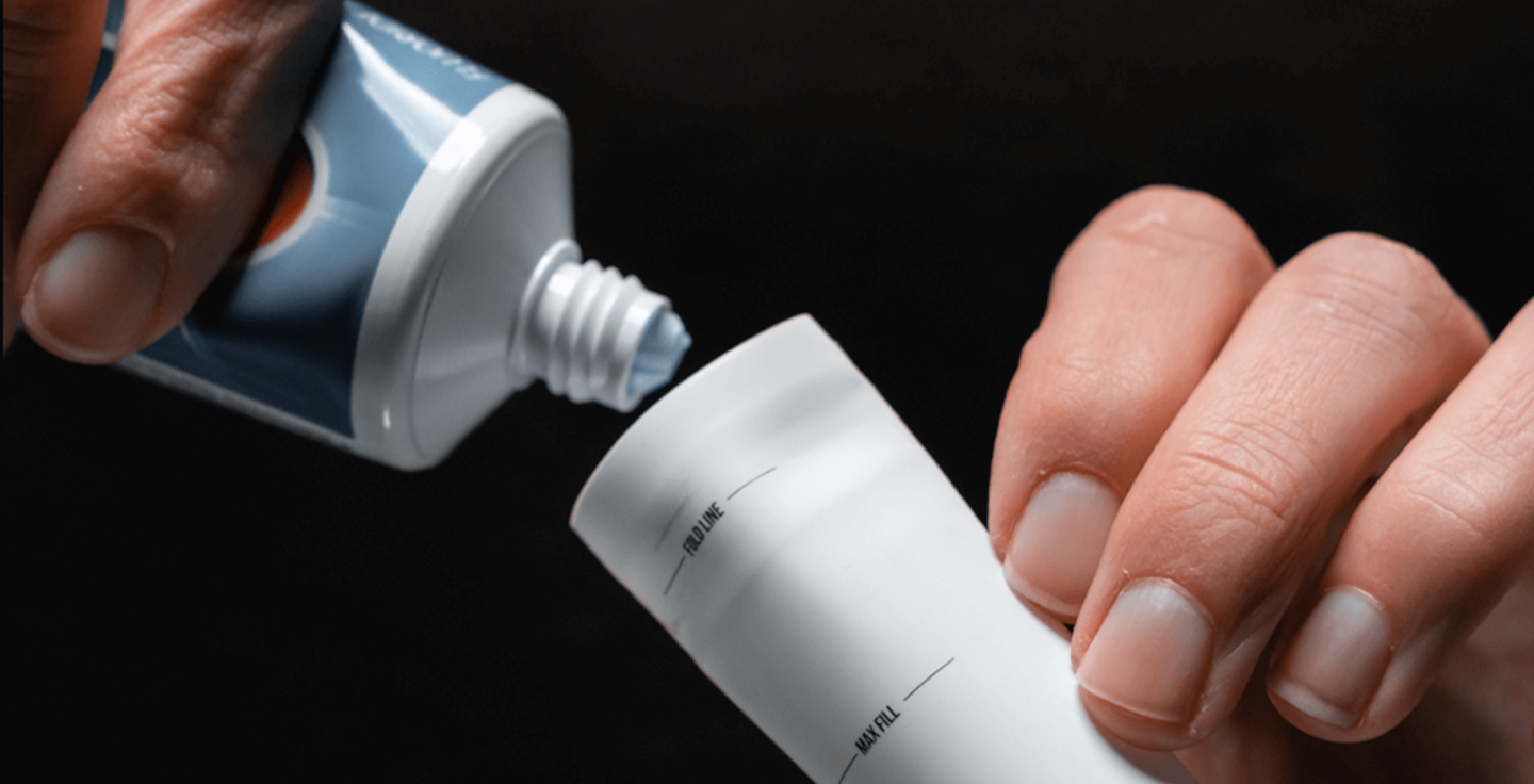 A close up of toothpaste being squeezed into a tube
