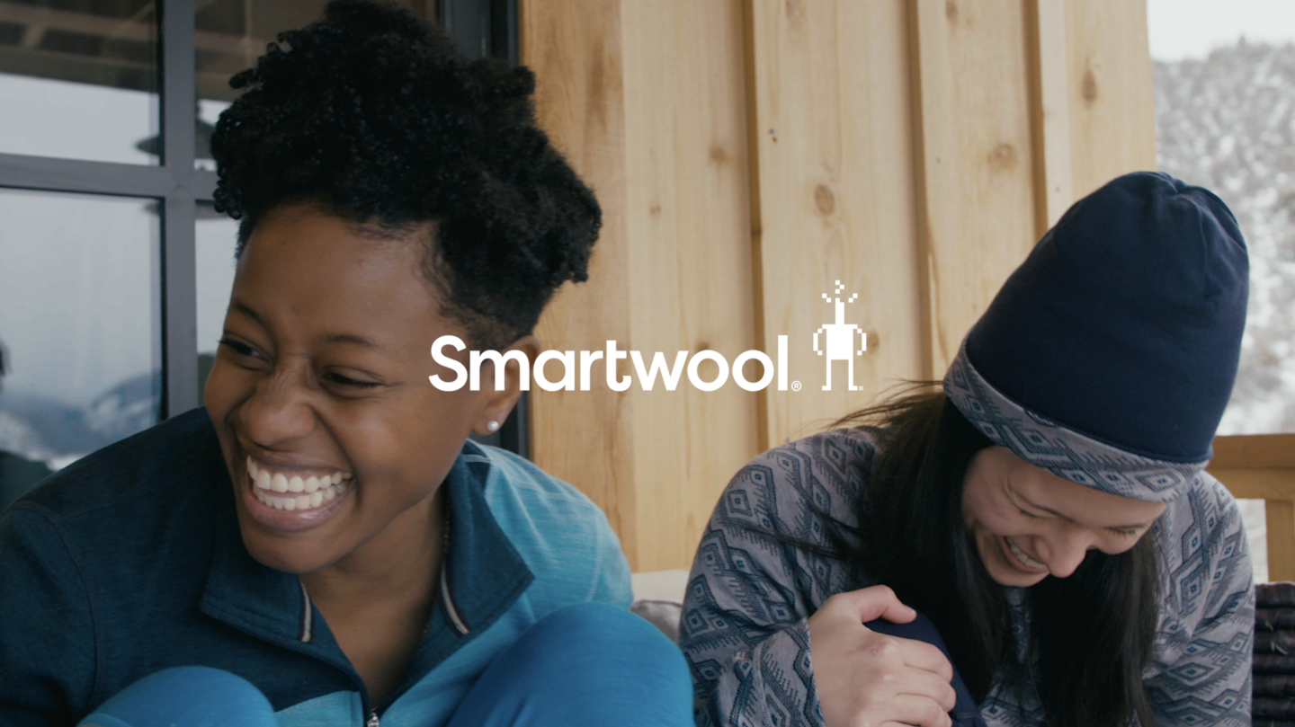 two women in smartwool apparel sitting and laughing
