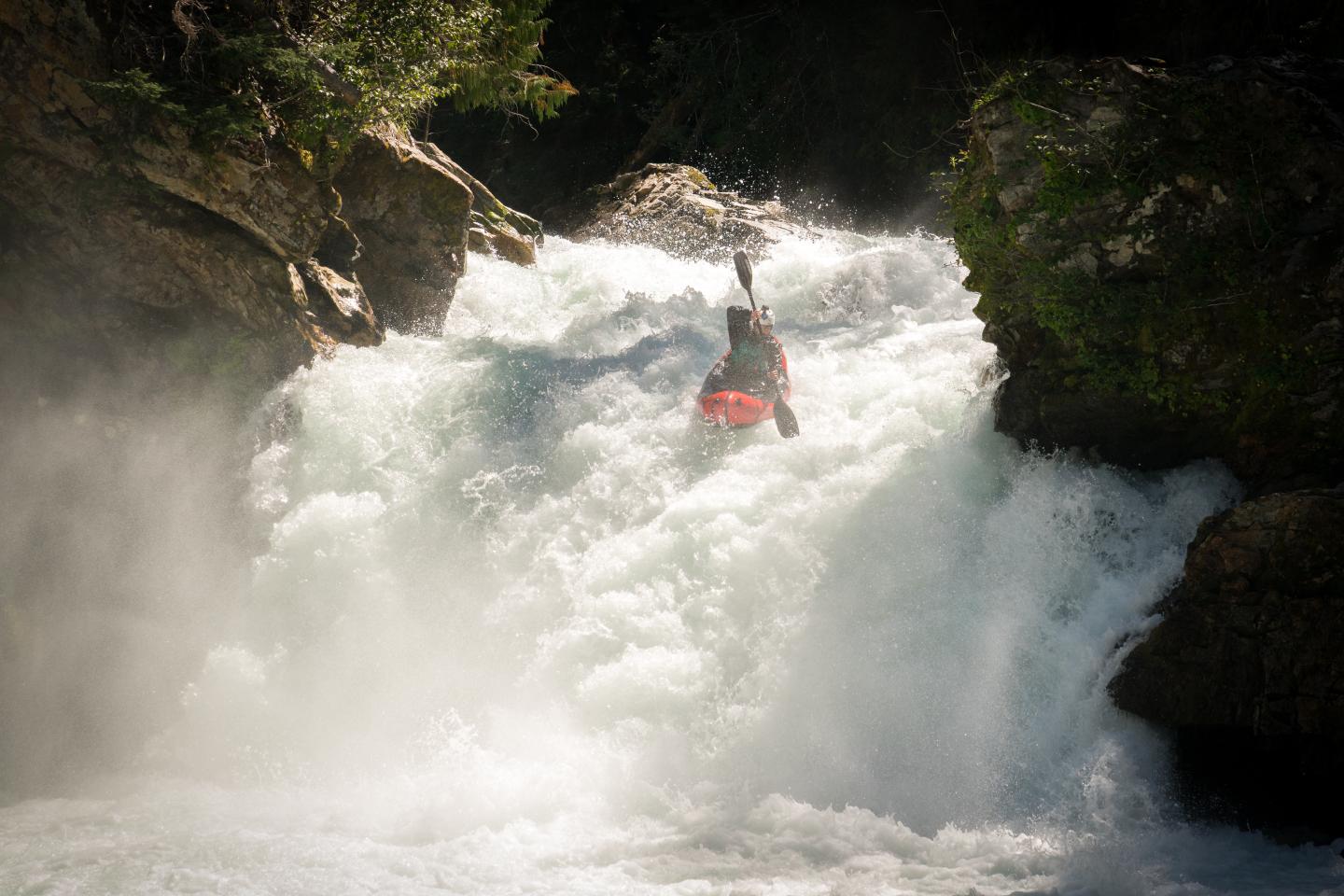 A person kayaking down a waterfall