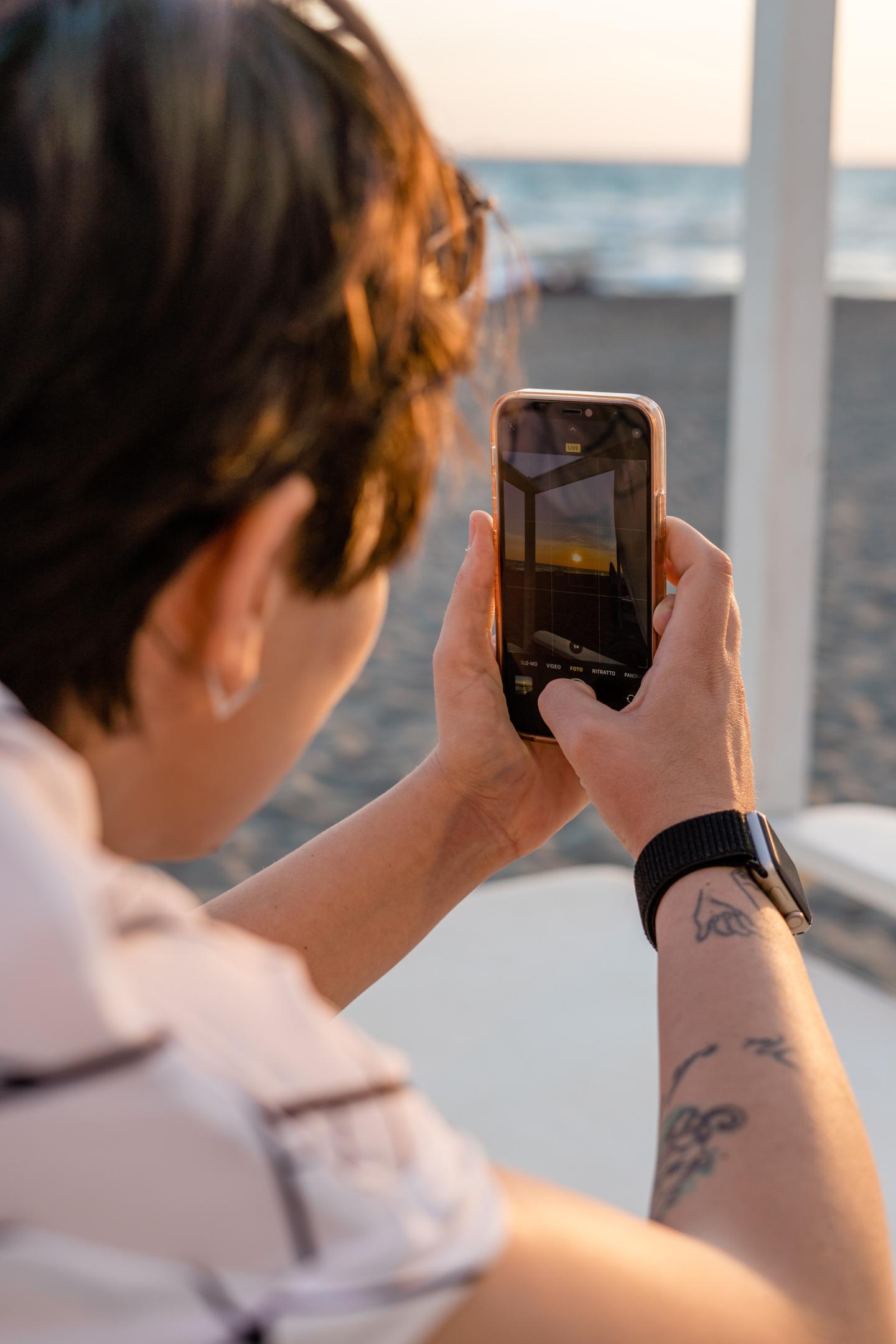 A person filming a sunset with a phone
