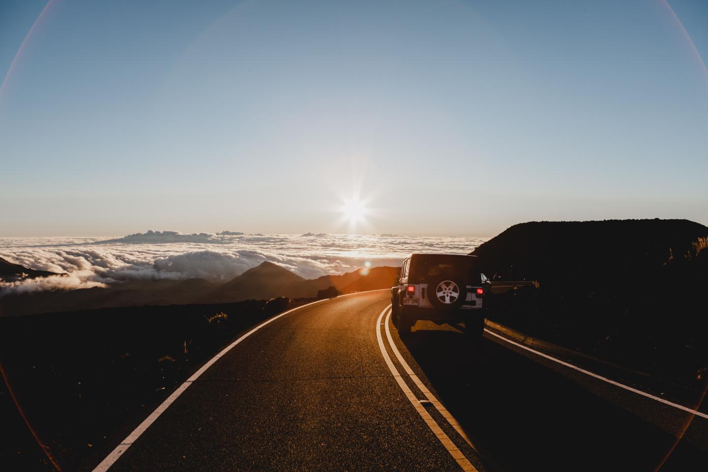 A car driving into the sunset
