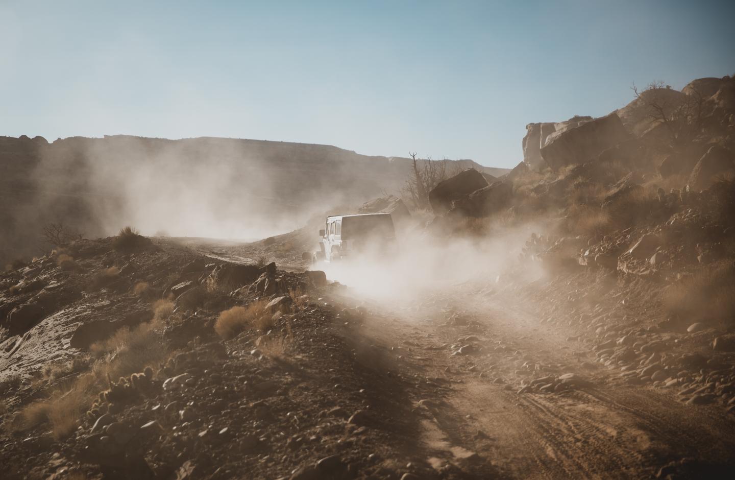 Jeep driving on dusty desert road