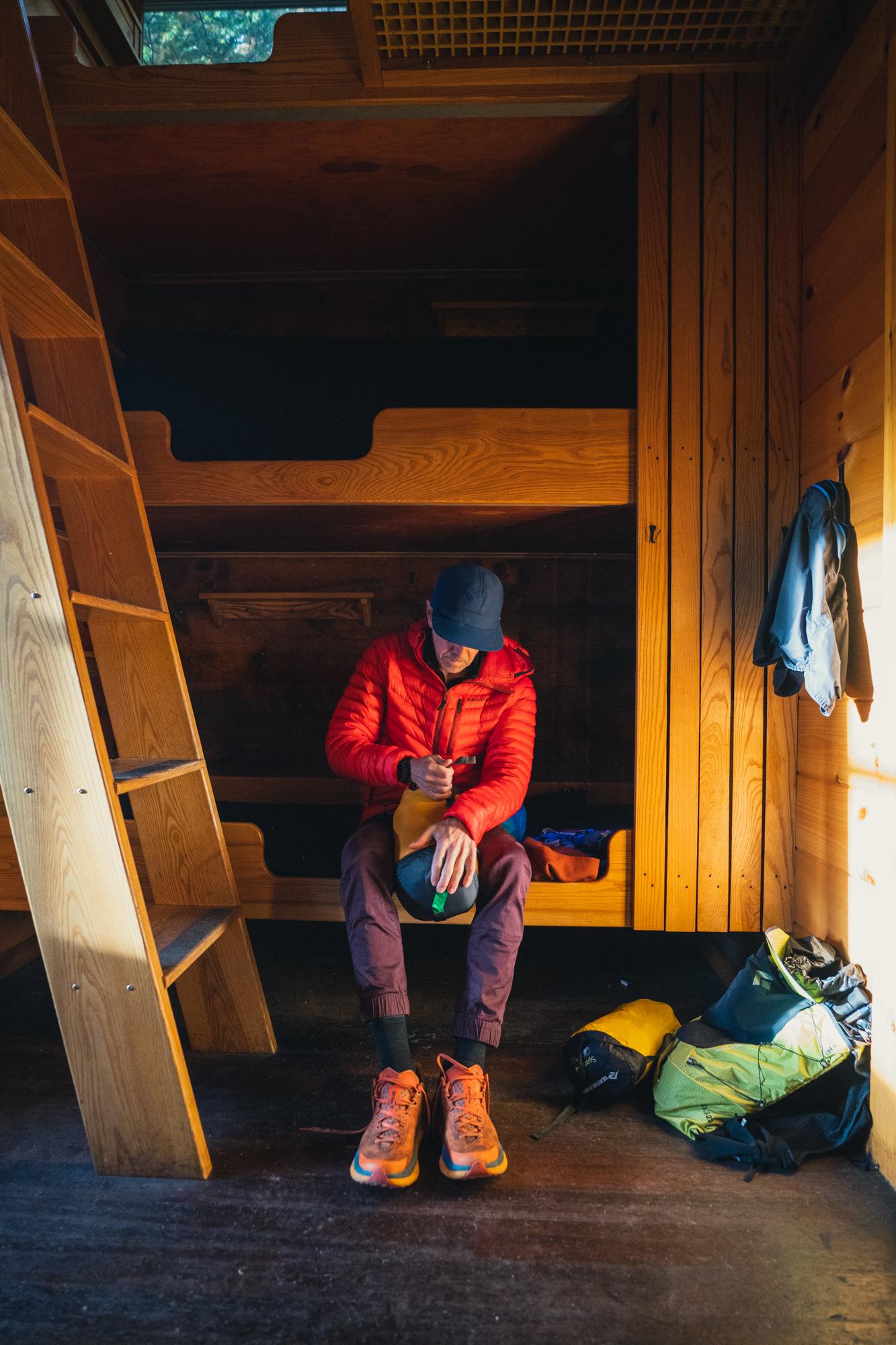 a man preparing gear for a hike in a hut