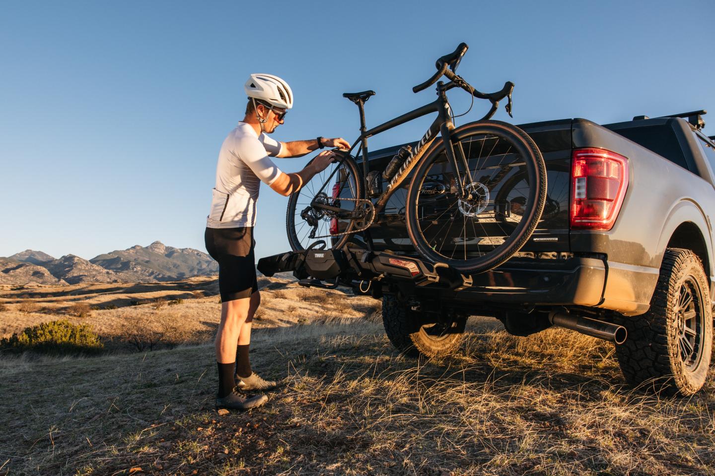 cyclist putting a bike on a Thule hitch rack
