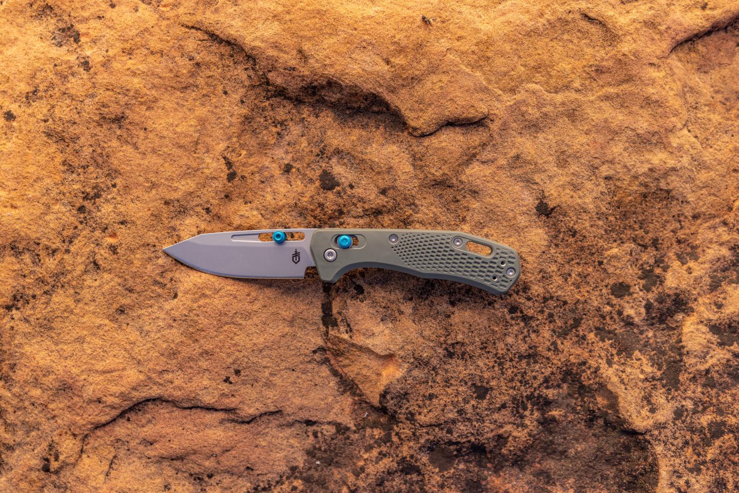 one pocket knife displayed on a rock