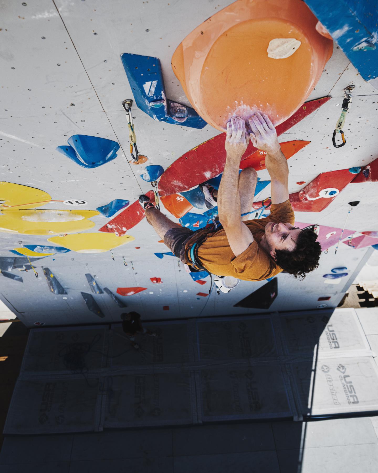 Man lead climbs in a gym
