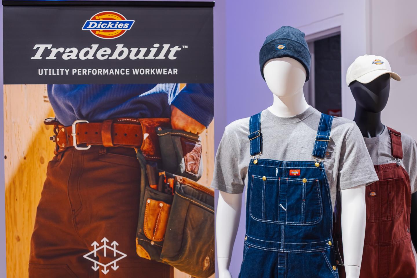 Mannequins in workwear near Tradeshow banner with tool belt.