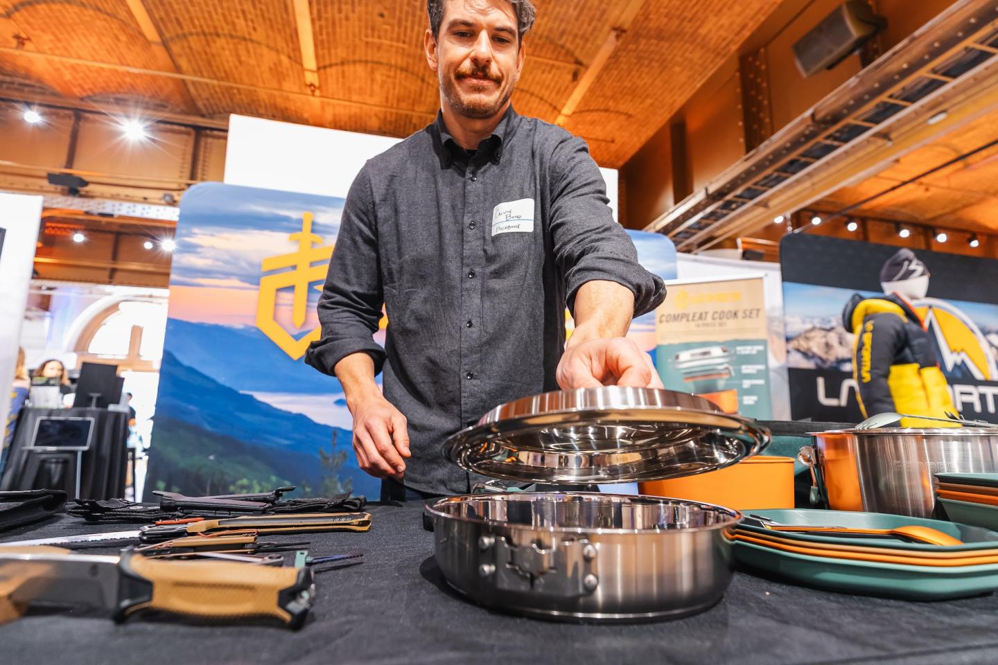 Man demonstrating cookware at an exhibition booth.
