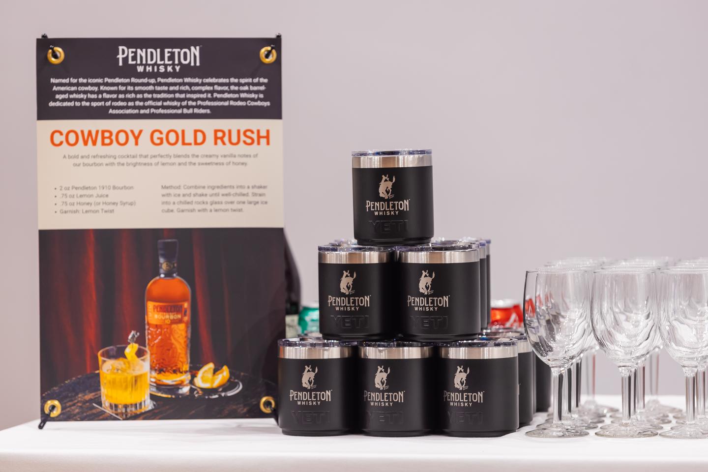 Whiskey promotion display with stacked tins and empty glasses.