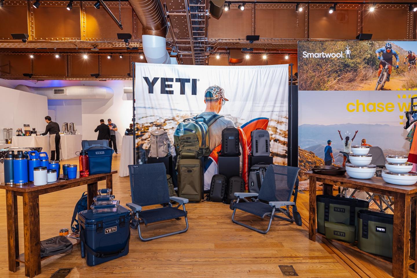 Outdoor gear display with chairs, bags, and camping items in a showroom.