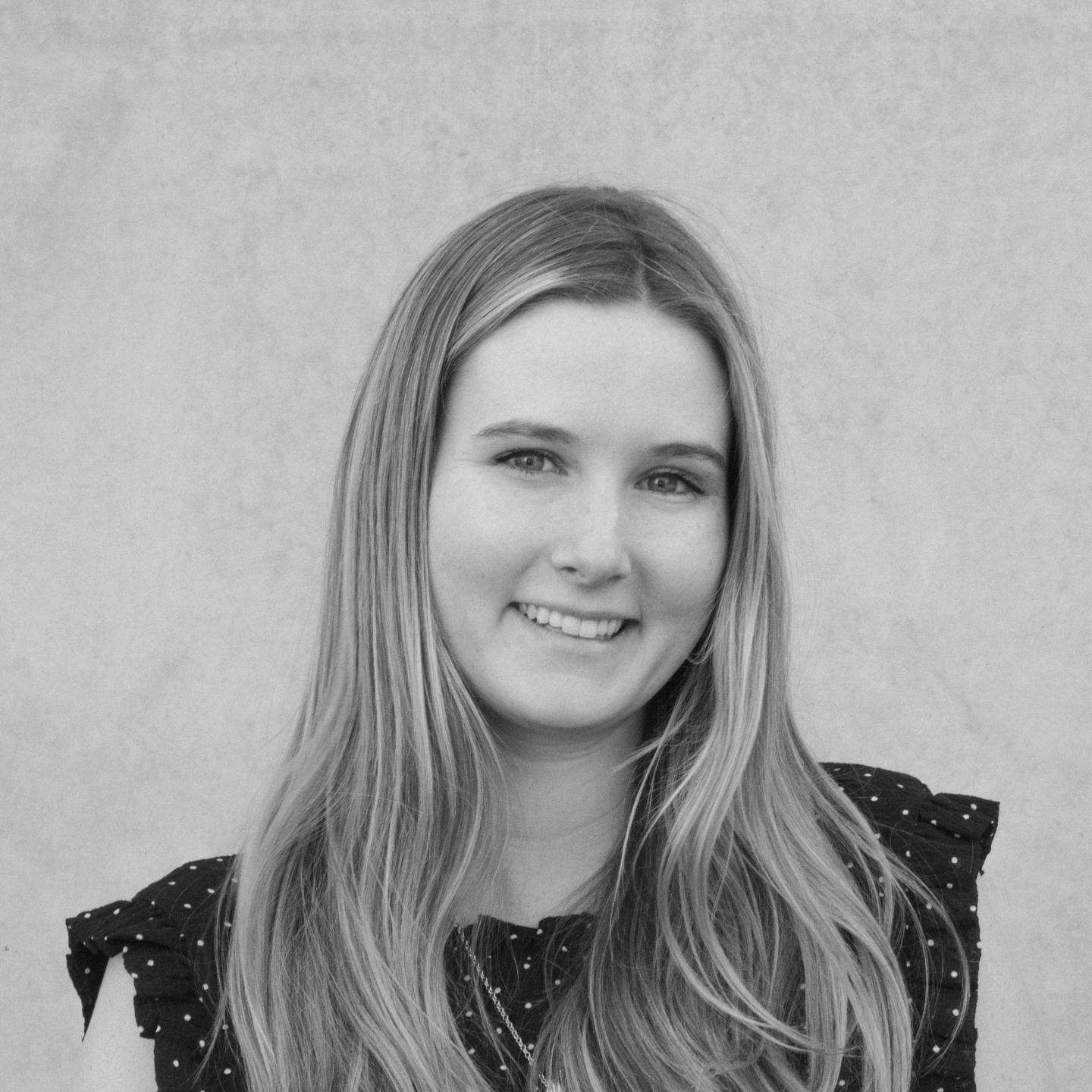 Smiling woman with long hair in black and white photo.