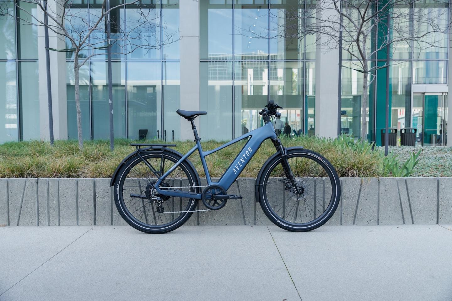Electric bicycle parked in front of a modern office building.