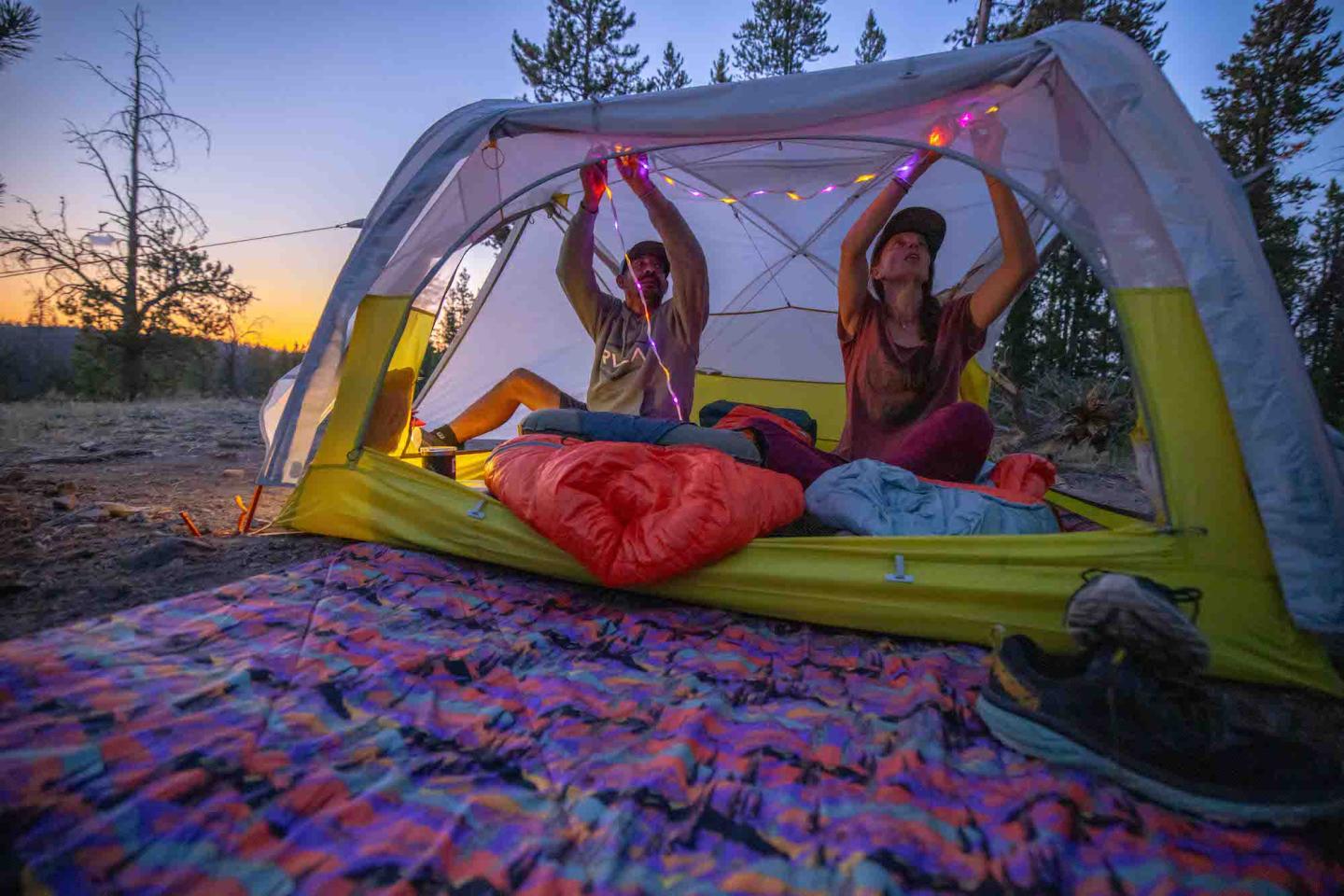 Two people in a tent at sunset