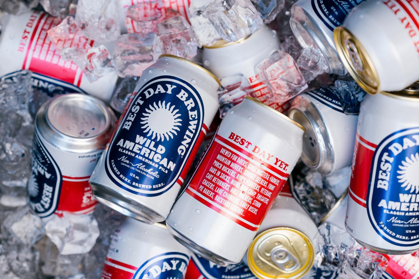 Cans of non alcoholic beer on ice, featuring blue and red labels.